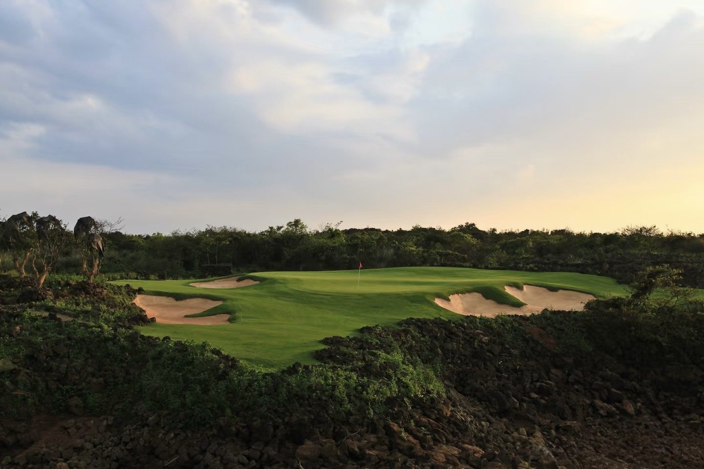 A palm-lined fairway running between walls of volcanic stone at Blackstone