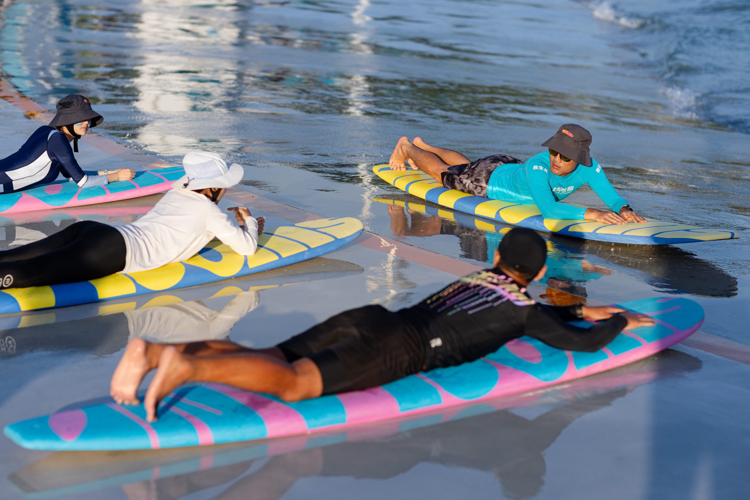 Surf coach teaching a beginner lesson in the PerfectSwell wave pool at Riyue Bay, Hainan